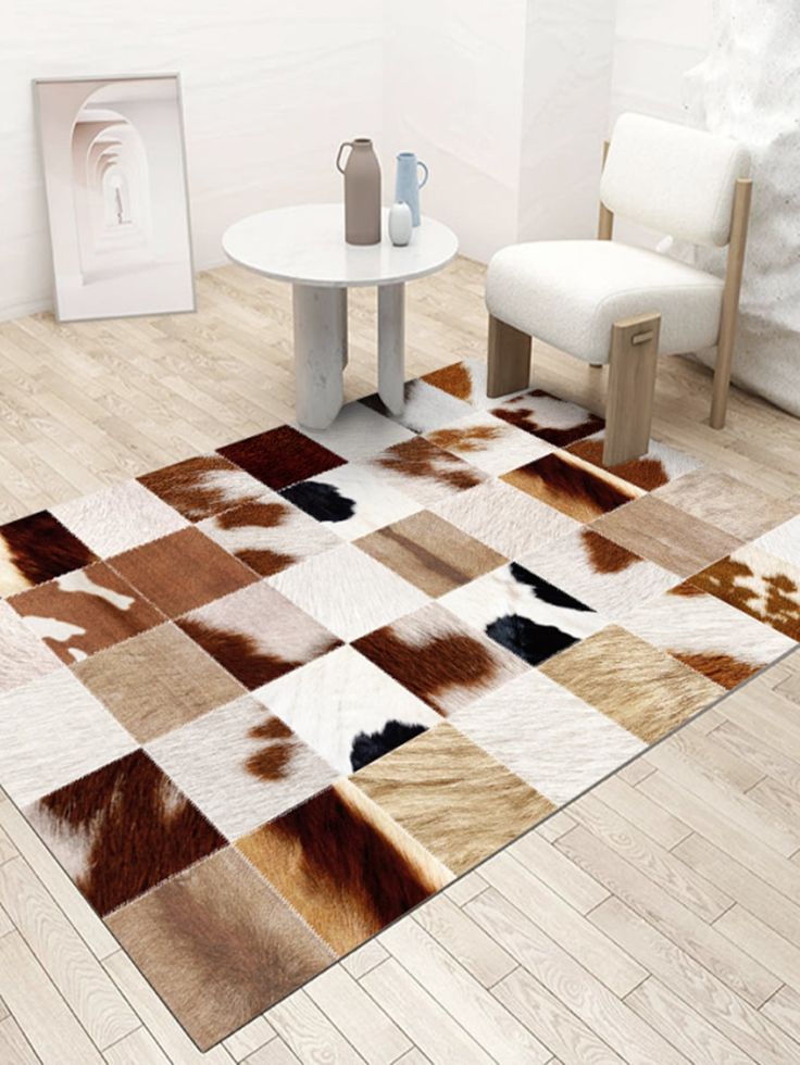 Cow Hide Rugs placed in a room with beautiful white chair cushion and table in it. 
